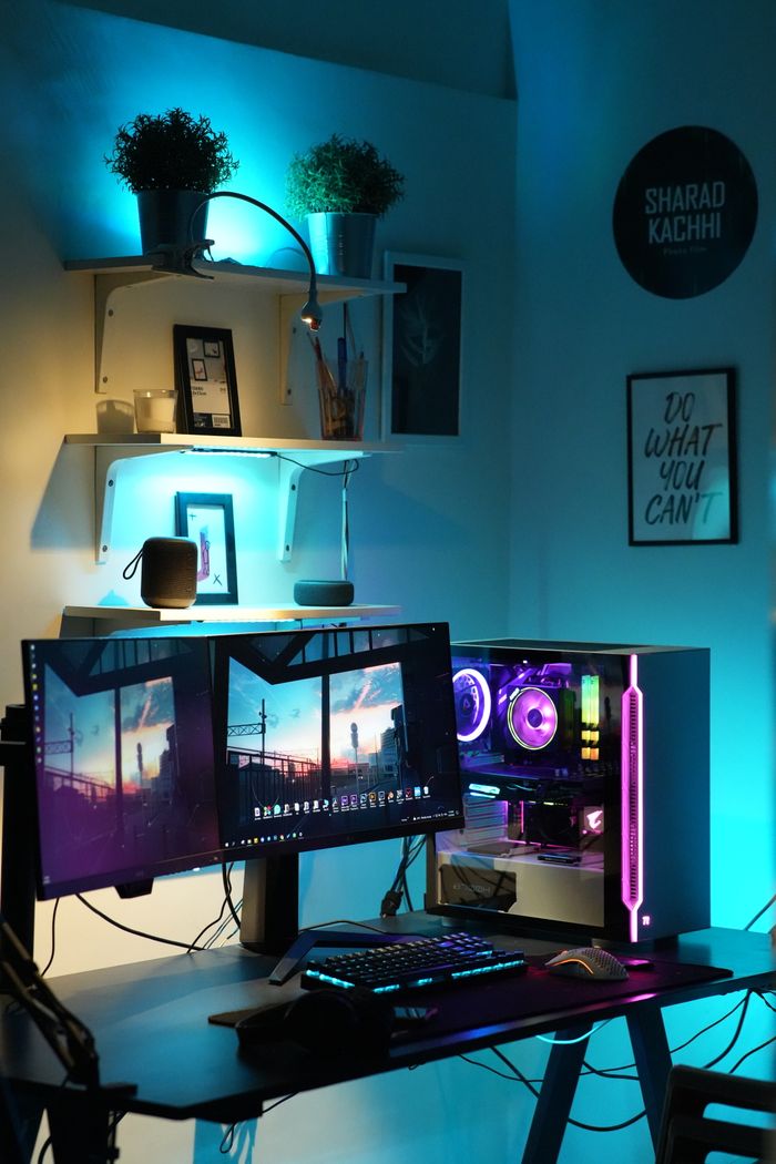 Illuminated desk setup featuring dual monitors and RGB lighting.